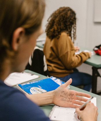 Student in a text with answers written on hand